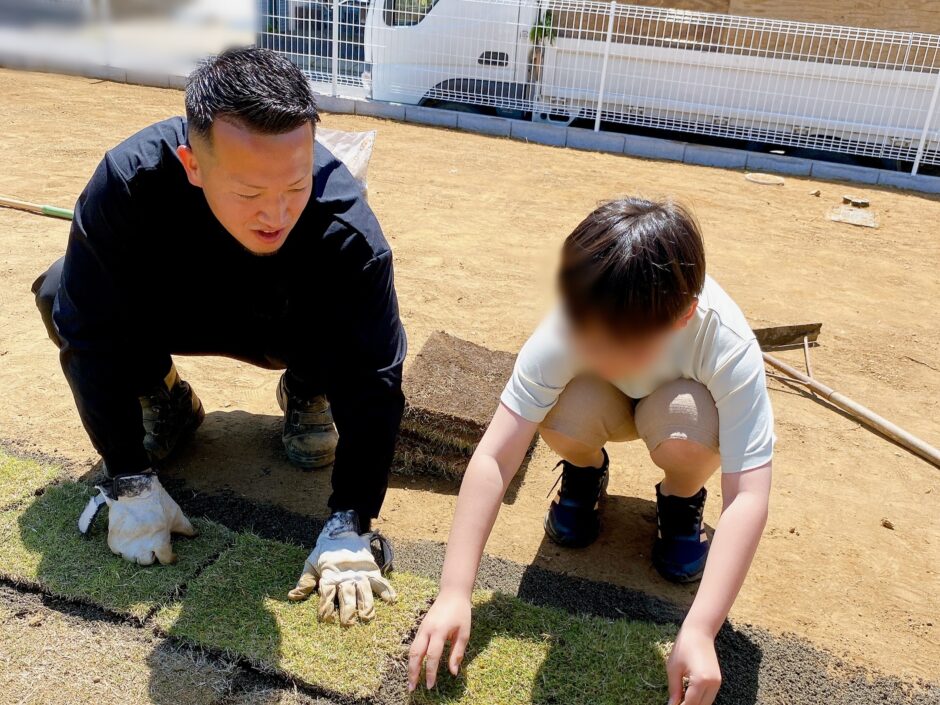 業者さんと子供で芝を張っている