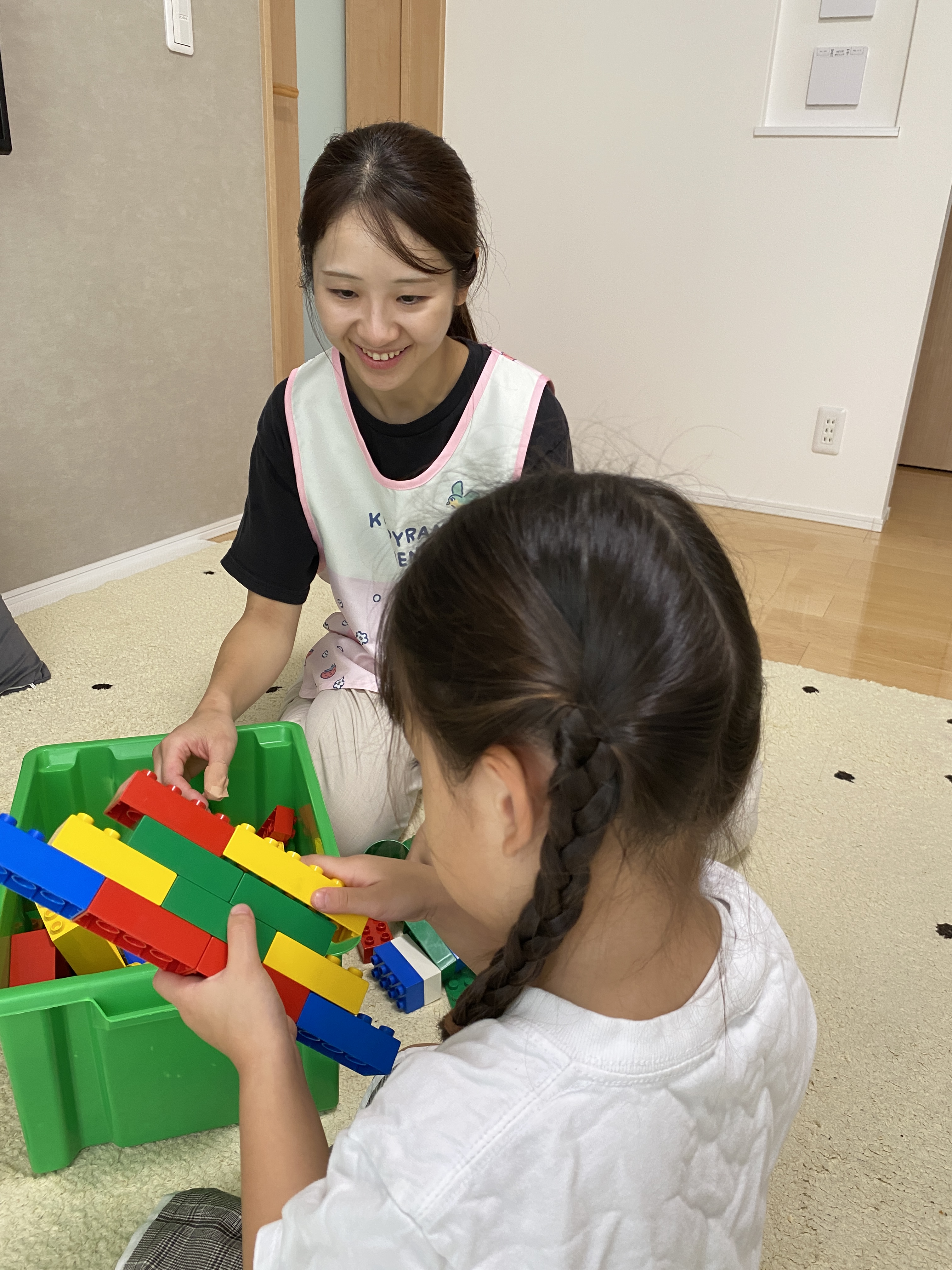 ブロックで遊ぶ子どもを見守る引田さん