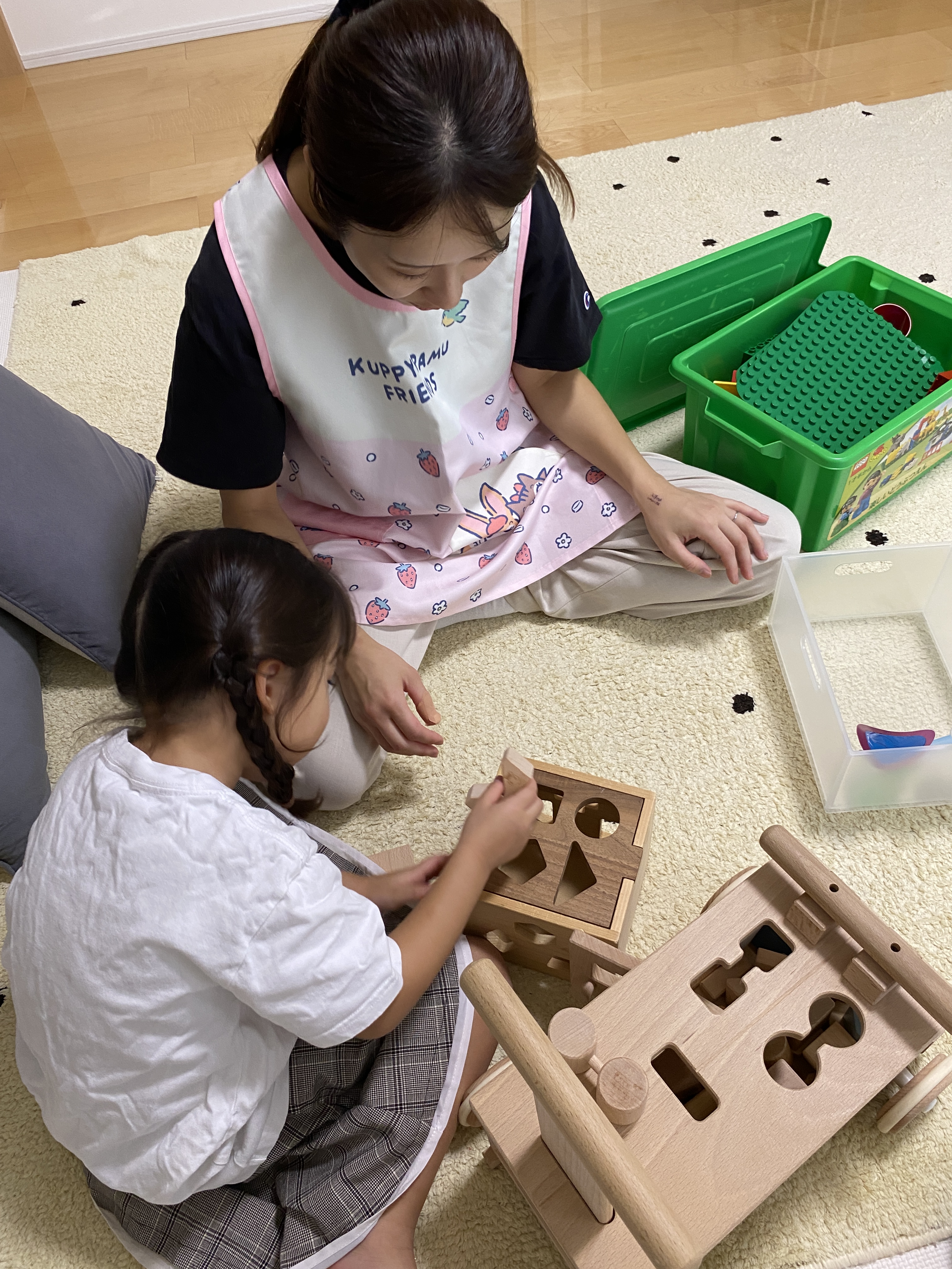 木のおもちゃで一緒に遊ぶ引田さんと子ども