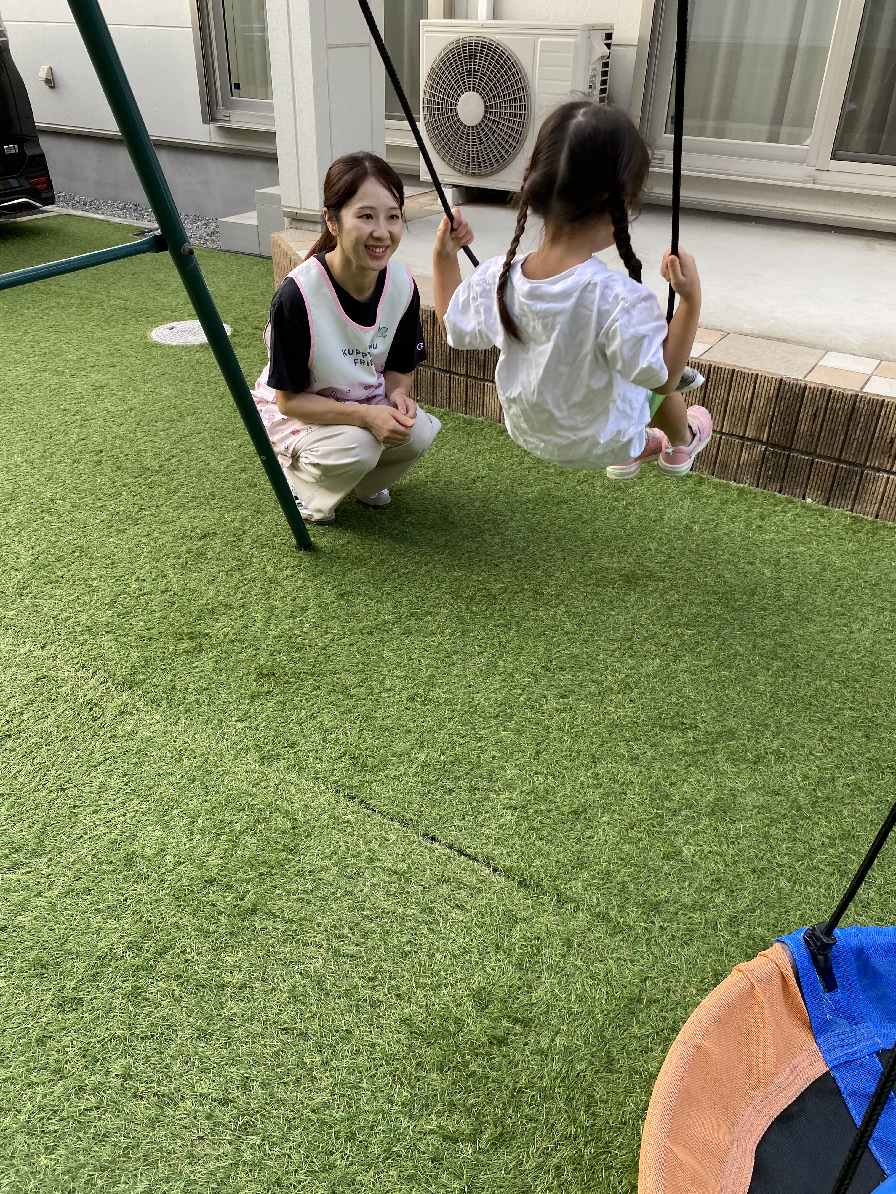 屋外で子どものそばにしゃがむ引田さん